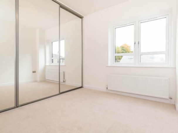 Bedroom featuring mirrored wardrobes at new homes.